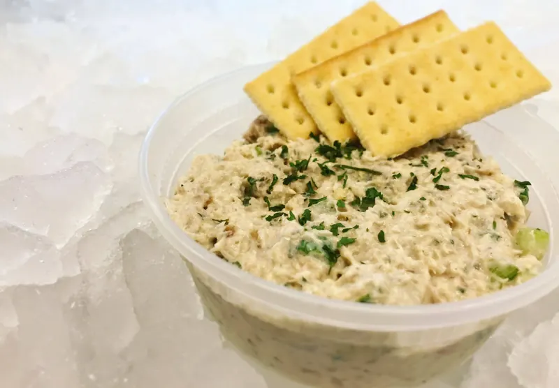 A tub of homemade smoked fish dip topped with crackers